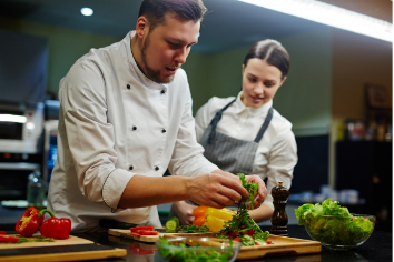 Eine Frau und ein Mann die im Hotel kochen